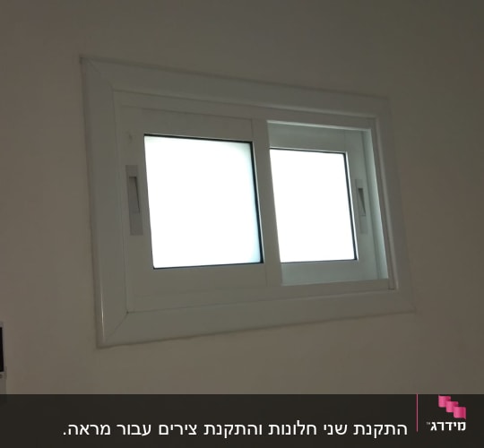 חלון אלומיניום עם מסגרת לבנה על קיר